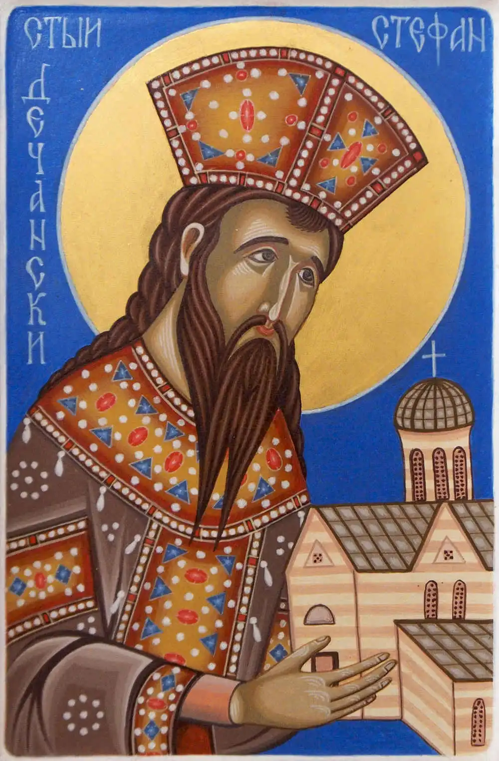 Icon of St. Stefan Dečanski with halo, holding and looking down towards monastery buildings